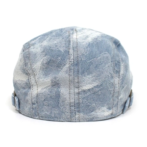 Detail view of the back of a blue washed denim beret featuring adjustable metal side buckles