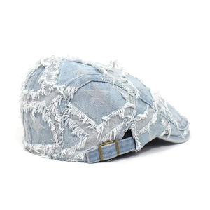 Detailansicht der Rückseite einer hellblauen Denim-Baskenmütze mit Stern-Patch und Schnalle