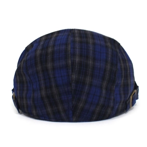 Detail view of navy plaid beret featuring a vintage brass adjustable side buckle