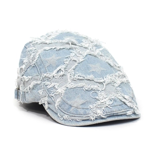 Detail der hellblauen Denim-Baskenmütze mit ausgefransten Kanten und Sternmustern
