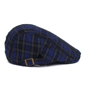 Detail of plaid beret hat showing side bronze metal adjustment buckle and classic pattern