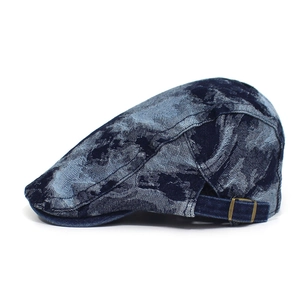 Detail view of washed denim beret with bronze metal buckle and side stitching texture