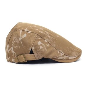 Detail of cotton flat cap featuring bronze metal buckle and artistic white ink splatter pattern