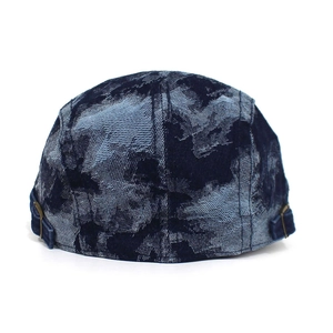 Detail view of washed denim beret featuring vintage camo texture and bronze buckle