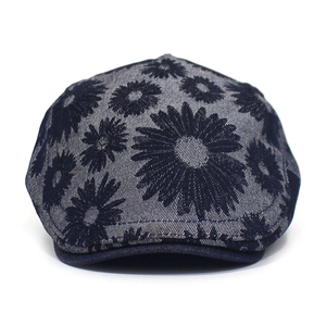 Detail of navy blue cotton beret hat featuring white daisy floral prints and visor