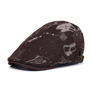 Detail view of brown ivy cap with silver printed patterns and metal buckle strap