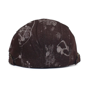 Detail of printed cotton flat cap featuring adjustable bronze metal buckle and texture