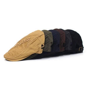 Detail of embroidered cotton flat caps in multiple colors with adjustable metal buckles