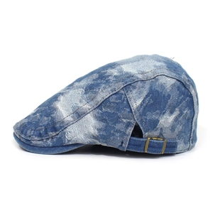 Detail view of washed blue denim beret showing vintage texture and adjustable metal buckle