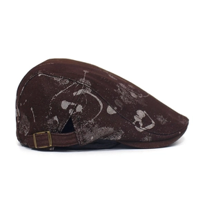 Detail view of brown flat cap showing vintage floral print and bronze metal side buckle