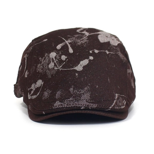 Macro detail of dark brown printed cotton beret hat showing texture and ink patterns