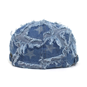 Detail der blauen Jeans-Baskenmütze mit Sternmustern und ausgefransten Saumkanten