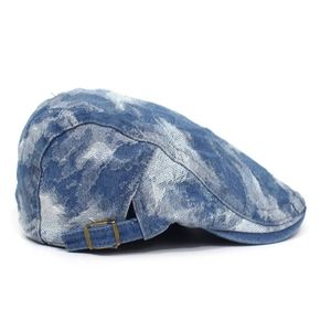 Detail of blue washed denim beret featuring vintage marble texture and brass metal buckle