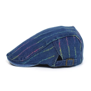 Makro-Detail einer gestreiften Denim-Schiebermütze mit verstellbarer Bronzeschnalle