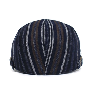 Detailed view of the adjustable bronze buckle and multicolor striped texture on the cap