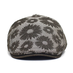 Detailed view of vintage cotton flat cap featuring dark floral daisy jacquard pattern