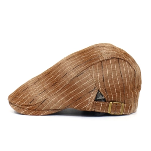 Détail d'un béret marron à rayures montrant la boucle de réglage en bronze et le tissu