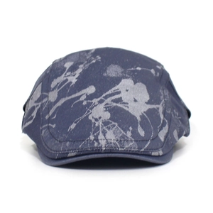 Detailed view of navy cotton flat cap with gray spray-paint graffiti art pattern