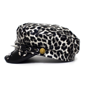 Detail of leopard print flat top military hat with silver metal spikes and black leather brim
