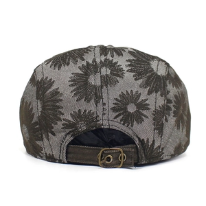 Detail of adjustable metal buckle and floral sunflower print on cotton beret cap