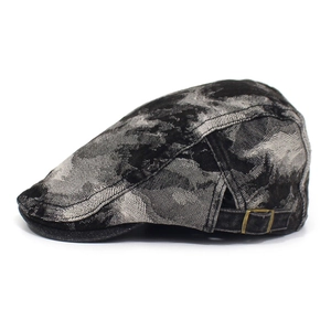 Detail of vintage flat cap with marble texture fabric and adjustable brass metal buckle