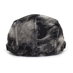 Detail view of washed denim beret featuring vintage metal side buckles and textured fabric