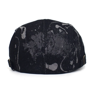 Detail of printed cotton beret hat showing gray abstract pattern and metal buckle