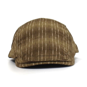 Détail de la casquette plate marron avec rayures verticales blanches et visière courte