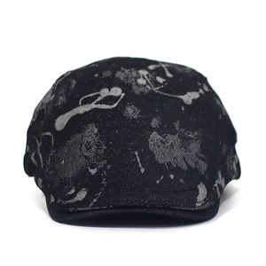 Detailed close-up of a black cotton ivy cap featuring gray abstract printed ink patterns