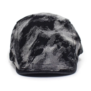 Detail view of washed denim beret featuring vintage distressed texture and grey black tones