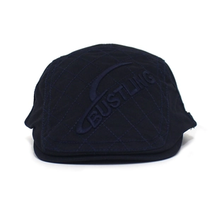Detail of diamond-quilted navy blue cotton beret hat featuring 3D embossed Bustling logo