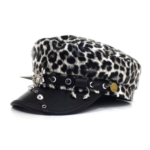 Close-up of leopard print flat top hat with silver studs and metal spider detail