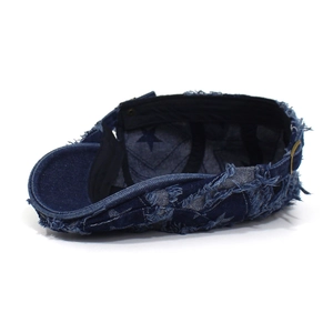 Detail der verwaschenen Denim-Baskenmütze mit hellblauem Sternenmuster und Used-Look-Effekt