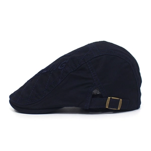 Detail of navy cotton flat cap with diamond quilting and embroidered KING lettering