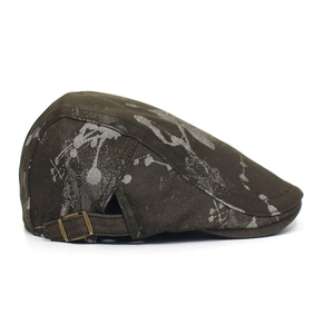 Detail view of vintage cotton flat cap featuring abstract ink splatters and metal buckle