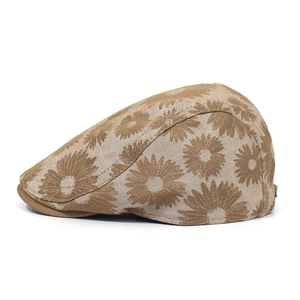 Close-up of brown floral jacquard flat cap with detailed daisy pattern and fine stitching