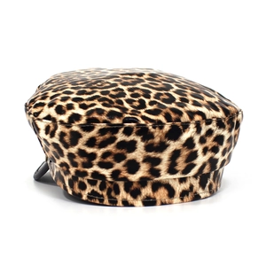 Detail van een baret met luipaardprint, faux fur textuur en een zwarte metalen gesp als accent