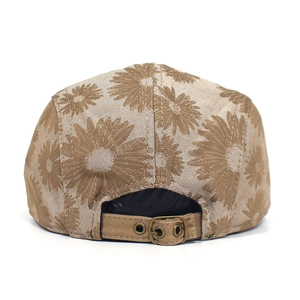 Detail view of the metal buckle adjustment strap on khaki floral cotton beret cap