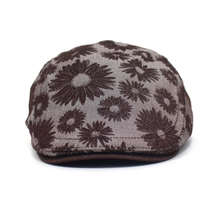 Detailed view of dark brown cotton flat cap with printed vintage floral daisy patterns