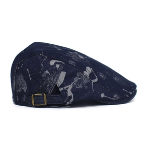 Detail showing the adjustable metal buckle on dark blue denim printed flat cap
