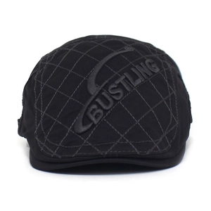 Close-up of black diamond-stitched cotton cap with detailed BUSTLING letter embroidery