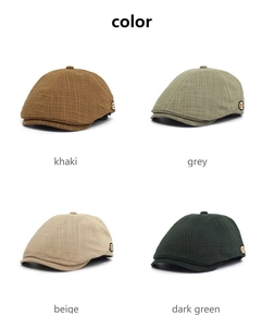 Detail der Schiebermützen in Khaki, Grau, Beige und Dunkelgrün mit Karo-Muster und m-Logo
