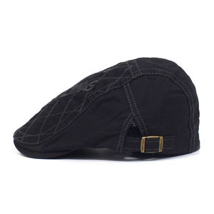 Detail of black cotton flat cap featuring diamond quilting and KING embroidery