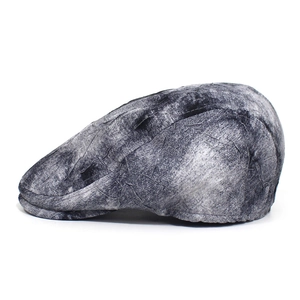 Close-up of black and grey marble texture with wrinkled fabric on the newsboy cap