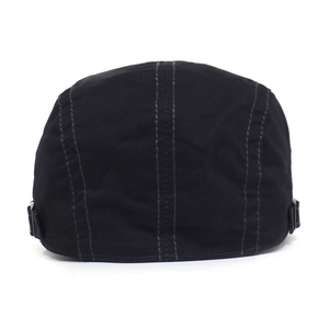 Detail view of cotton beret featuring adjustable metal side buckles and gray back stitching