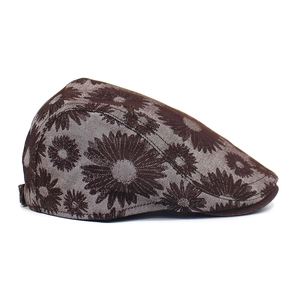 Close-up detail of white daisy floral print on tan canvas newsboy cap fabric texture