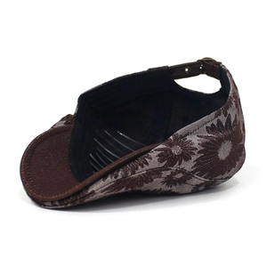 Detail view of cotton floral newsboy hat showing the sunflower pattern and adjustable strap