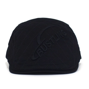 Detail of black cotton ivy cap with quilted diamond pattern and embossed BUSTLING logo
