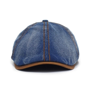 Detail of blue washed denim octagonal hat featuring contrast stitching and brown leather trim