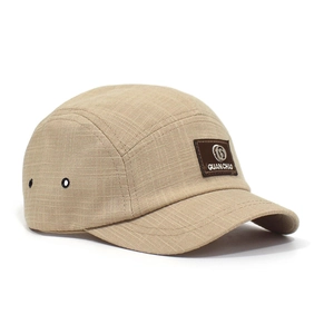 Detail van een kaki 5-panel campingpet met leren patch en metalen ventilatiegaatjes